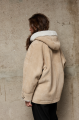 Stylish suede sheepskin coat made of natural sheepskin in beige color with a hood